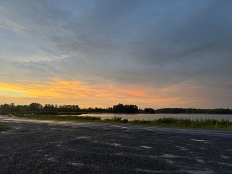 Serene summer sunset over tranquil waters in Rock Hall, Maryland, with vibrant pastel skies.