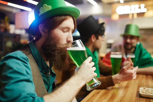 Man in Green Shirt Drinking Green Beer