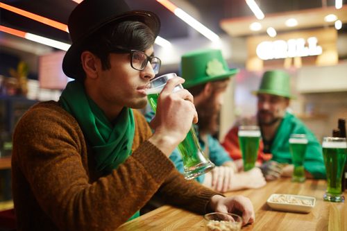 Free Group of adults enjoying green beer in a festive St. Patrick's Day celebration. Stock Photo