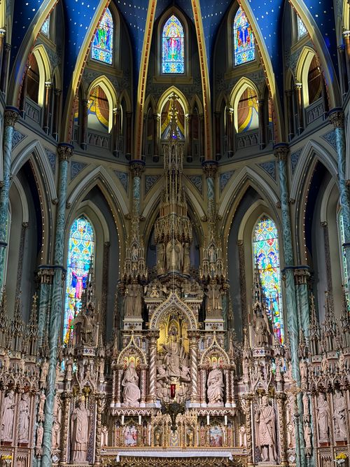 Free Detailed view of a Gothic cathedral interior with an elaborately carved altar and colorful stained glass windows. Stock Photo