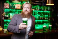 Bearded Man in Gray Suit Holding Green Beer