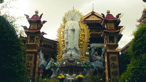 Free A serene Buddhist statue at the entrance of a decorated temple in Ho Chi Minh City, Vietnam. Stock Photo