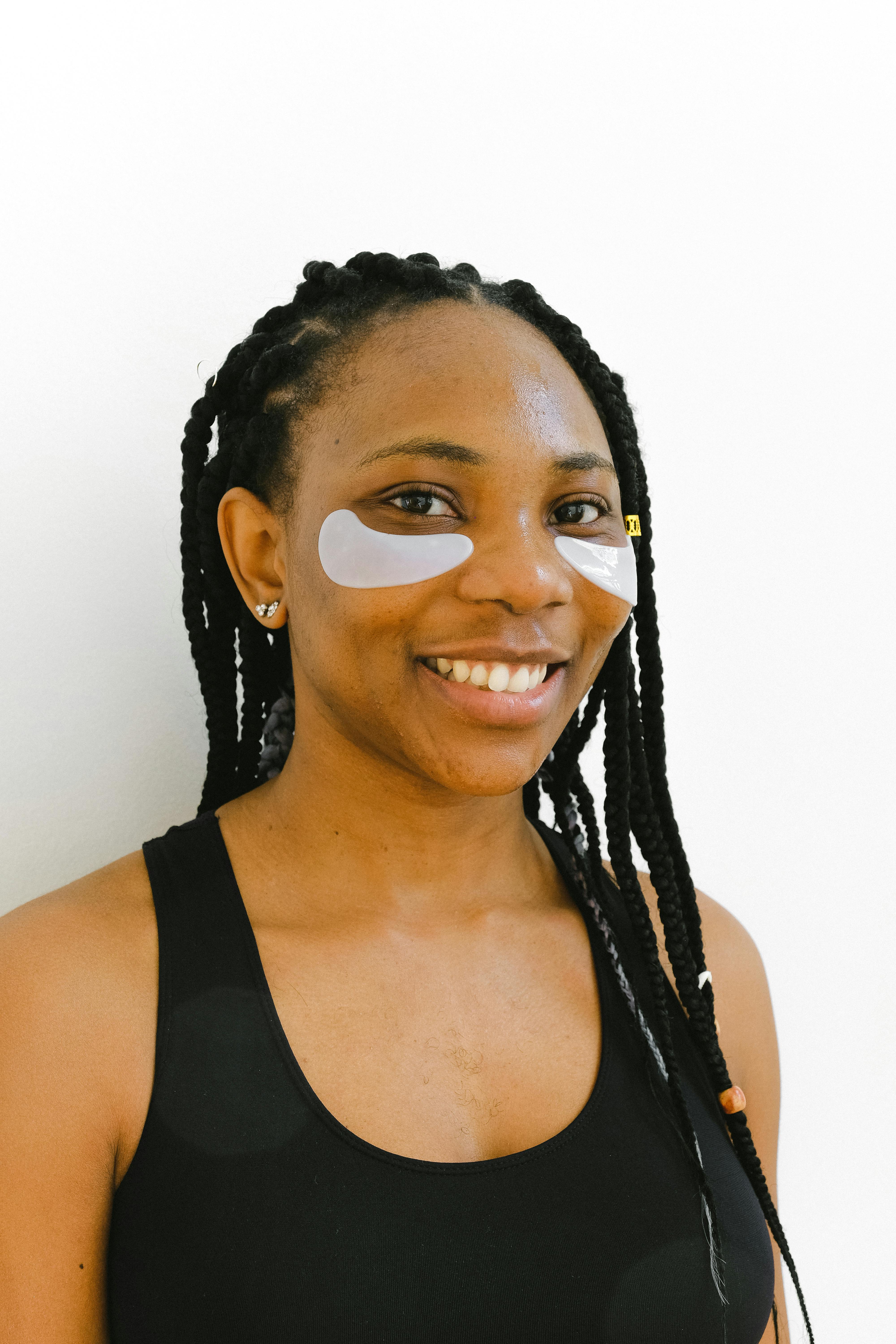 一位微笑的女人的肖像，辫子，戴着眼罩，穿着黑色背心