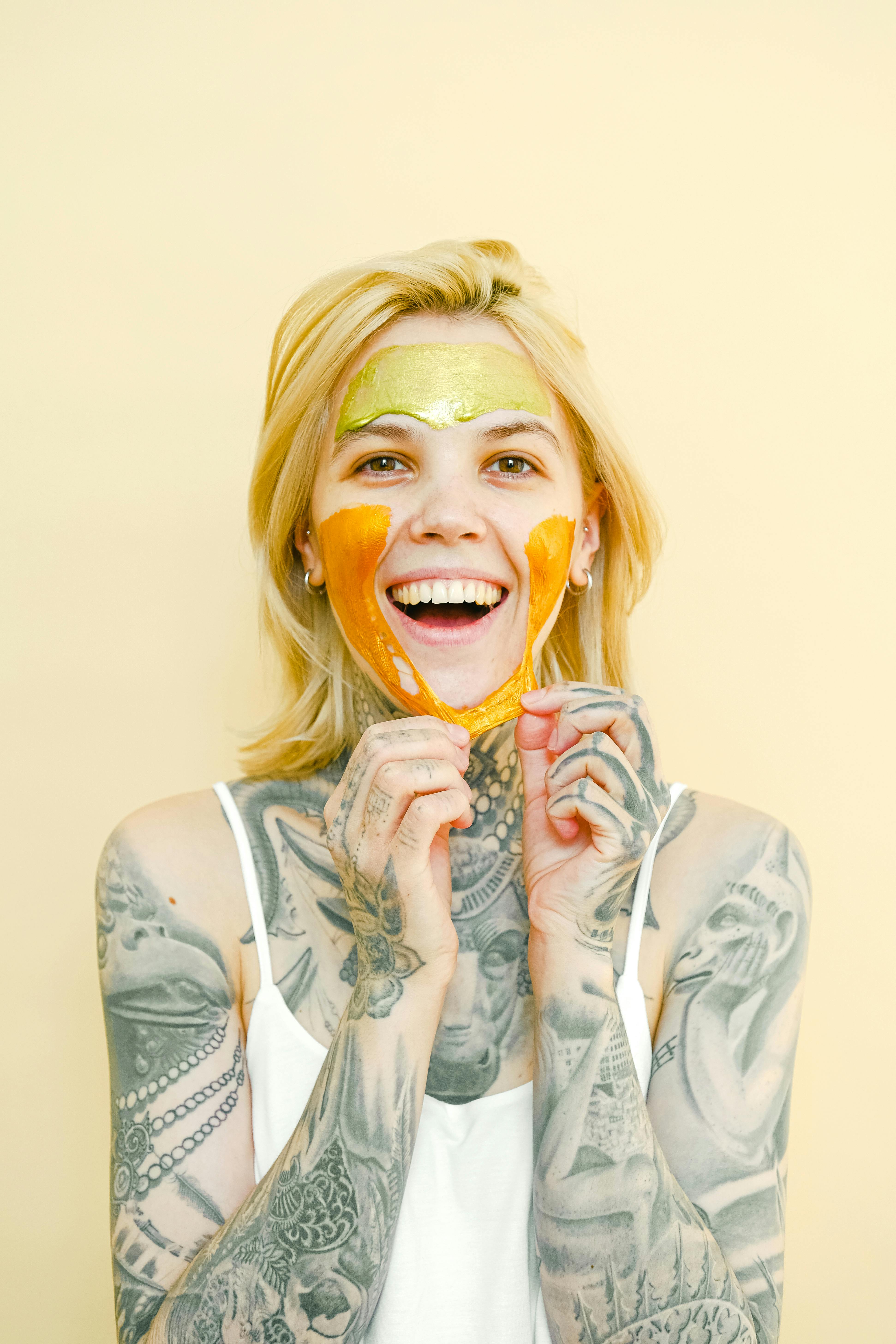 happy tattooed woman in peel off mask