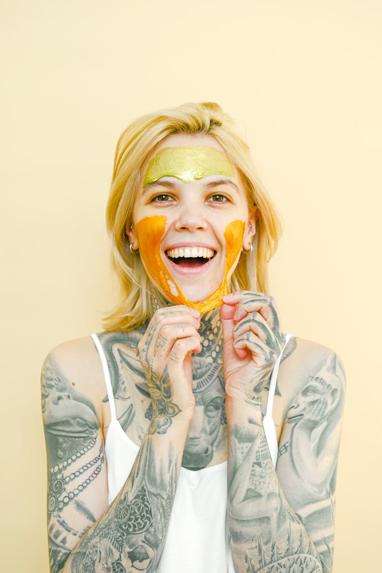 Happy Tattooed Woman In Peel Off Mask