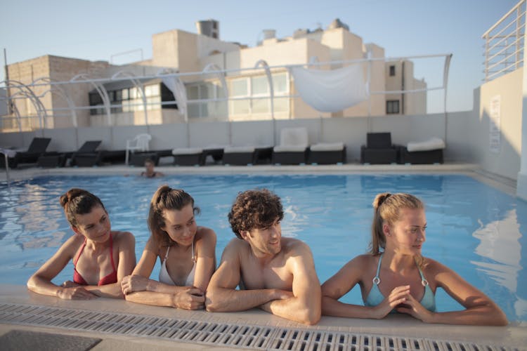 A Group Pf Friends Sitting On Swimming Pool