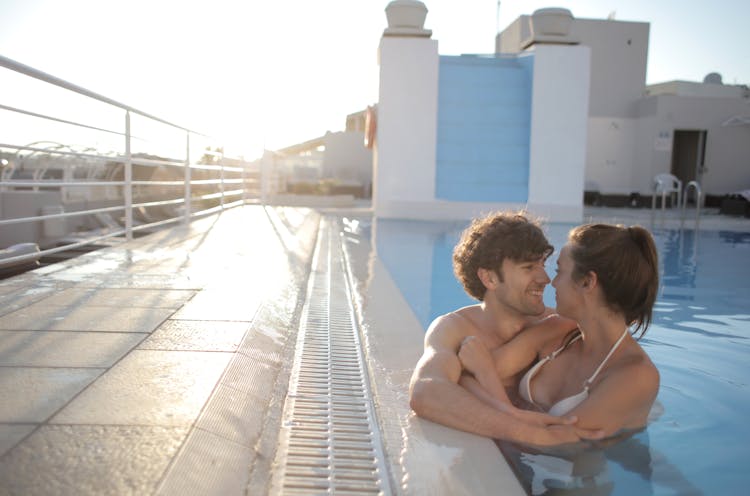 Happy Couple Embracing In Swimming Pool In Summer