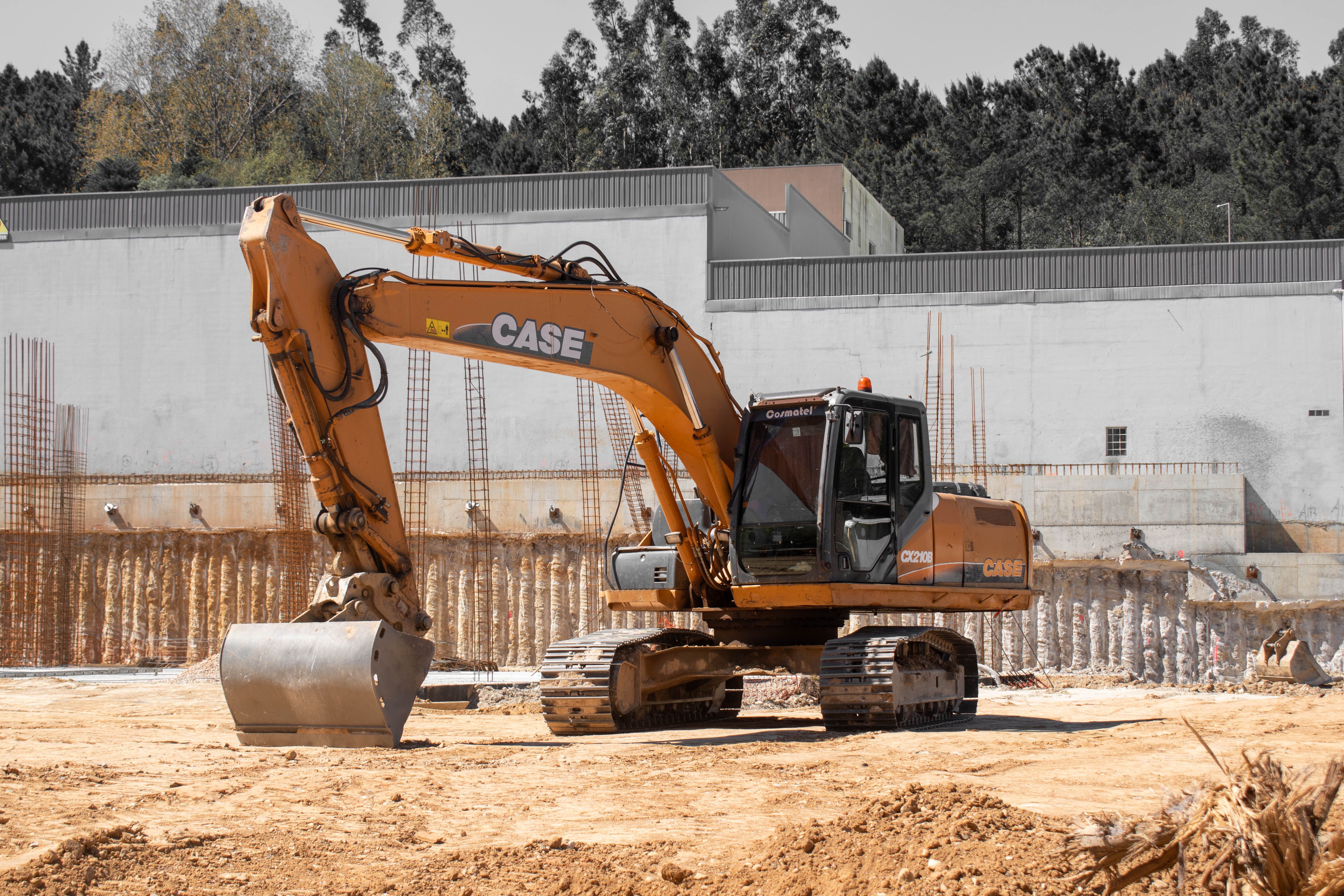 A large excavator positioned at an active construction site with clear skies.