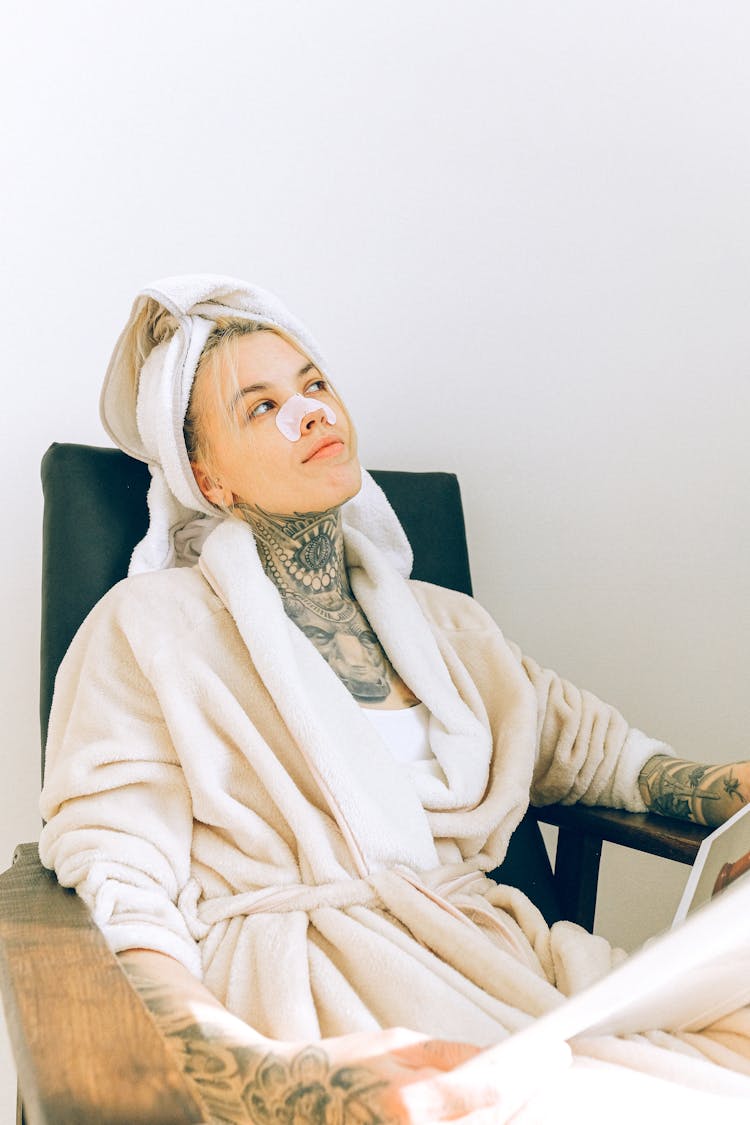 Woman In Bathrobe And Nose Mask Sitting In Spa Salon