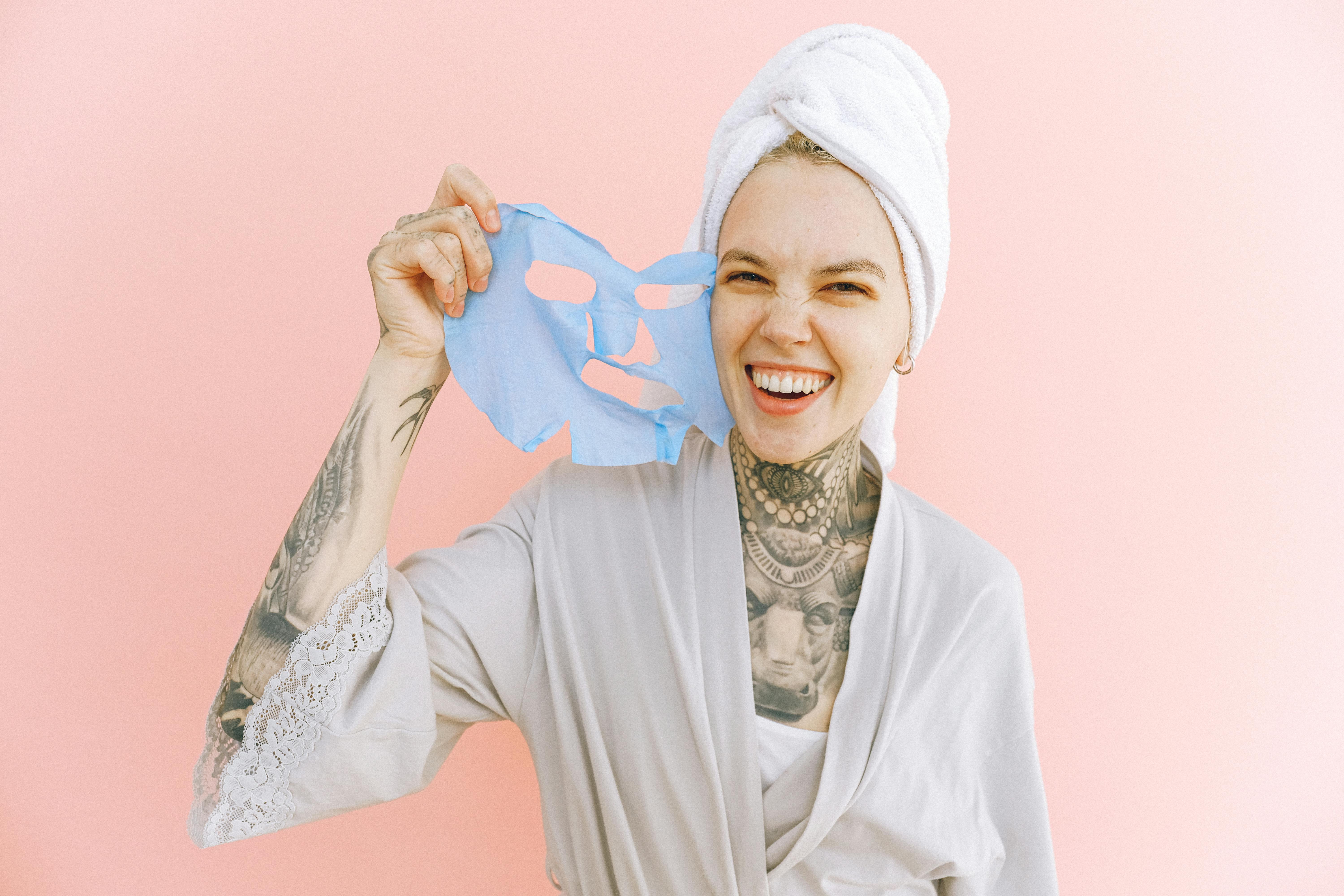 Free Happy woman removing face mask after taking bath Stock Photo