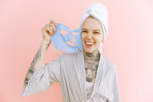 Free Happy woman removing face mask after taking bath Stock Photo