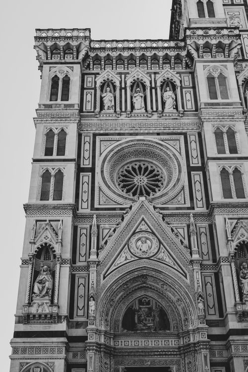 Free A detailed black and white image of the Florence Cathedral's ornate facade showcasing Gothic architecture. Stock Photo