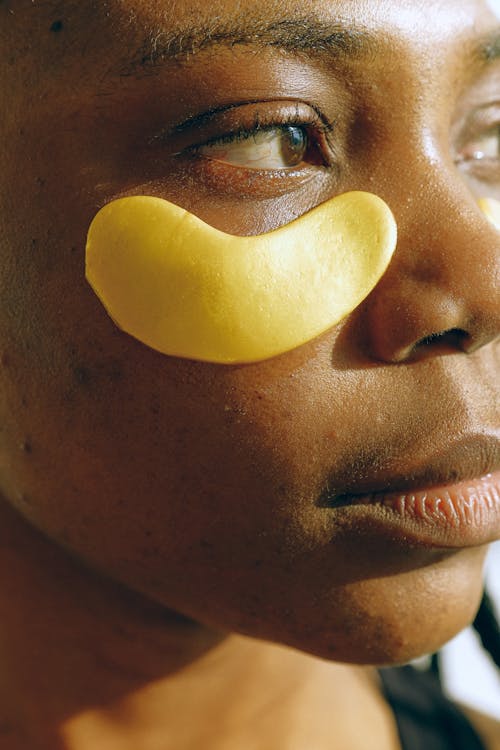 Young black woman during cosmetic procedure for eyes