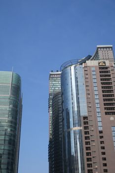 A view of modern skyscrapers rising against a clear blue sky, showcasing urban architecture.