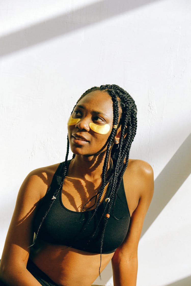 Young Black Satisfied Woman With Golden Collagen Patches Under Eyes