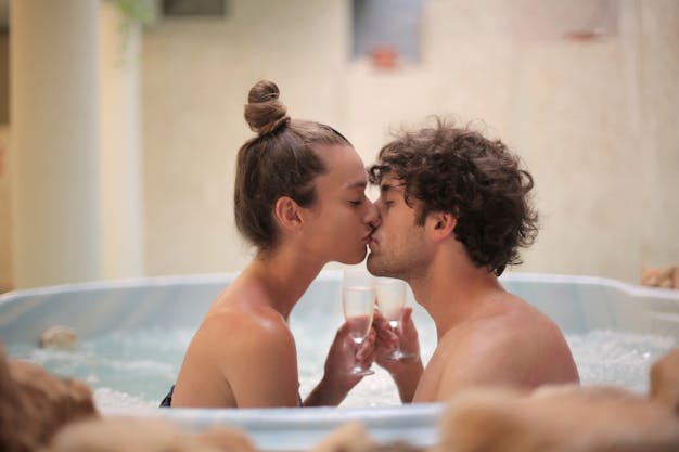 Happy couple kissing in bath during romantic leisure at home