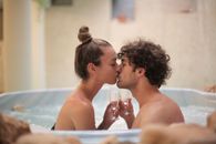 Happy couple kissing in bath during romantic leisure at home