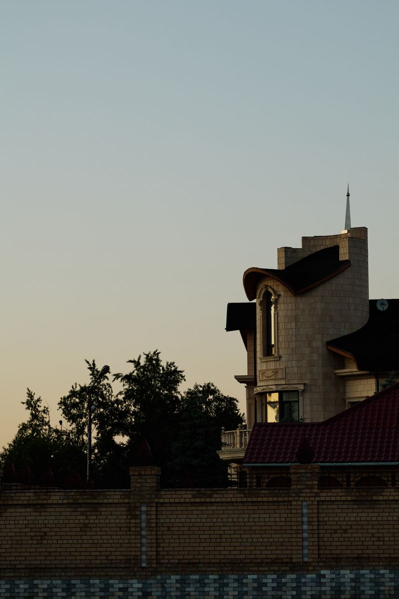 A house silhouetted against an evening sky, photo by Primitive Spaces on Pexels