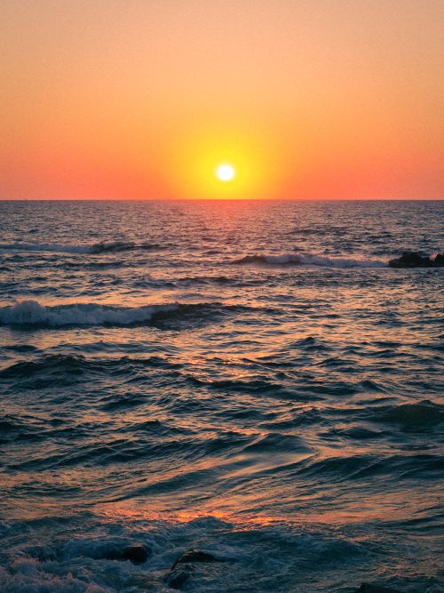 Free Vibrant sunset casting warm hues over the Mediterranean waves in Alexandria, Egypt. Stock Photo