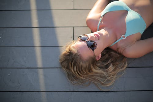 Sensual young woman resting on poolside in summertime