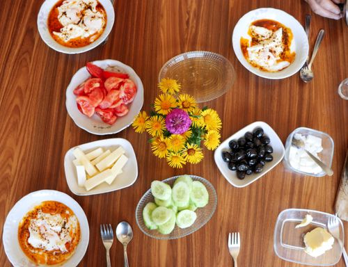 Free Aerial view of a vibrant breakfast table with various dishes and a floral centerpiece. Stock Photo