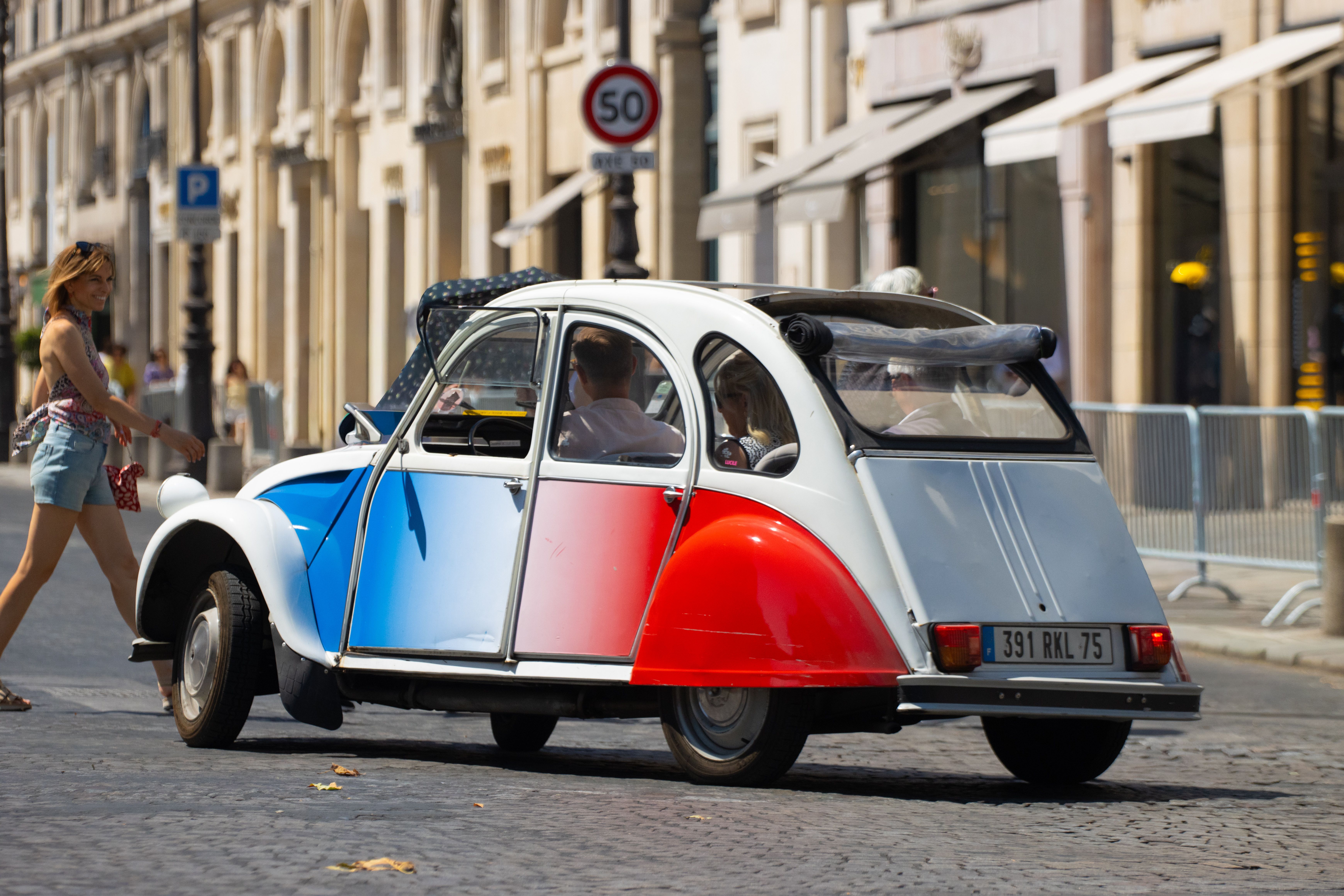 Vintage Citroën 2CV in red, white, and blue parked in Paris