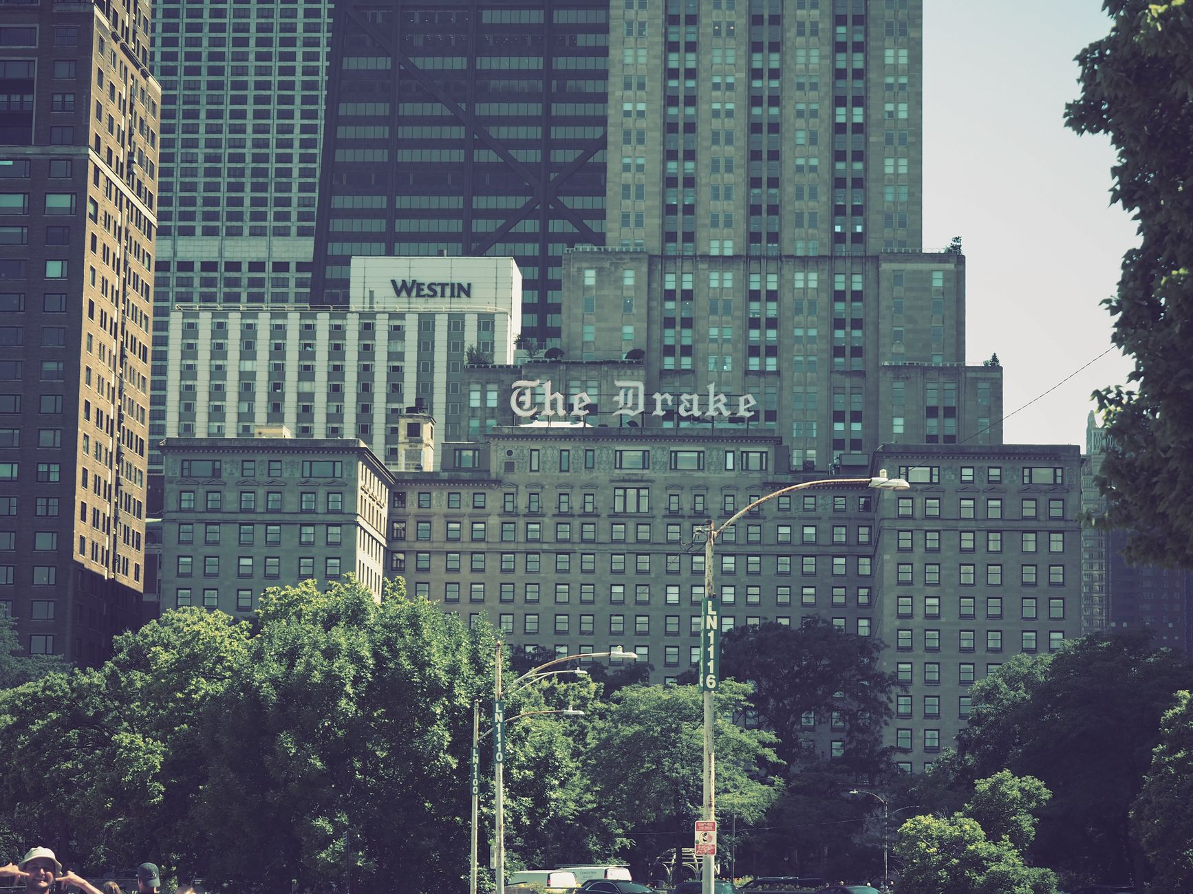 View of iconic The Drake Hotel and surrounding skyscrapers in downtown Chicago on a sunny day.
