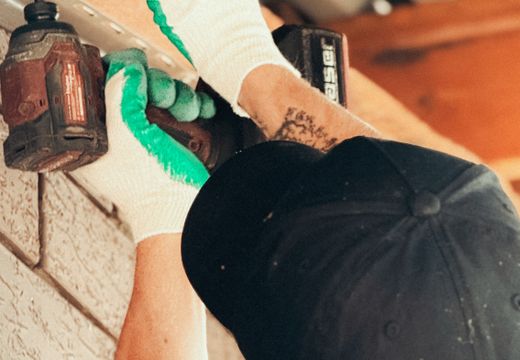 Handyman installing an outdoor light with a cordless drill