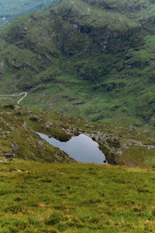 Free A breathtaking view of verdant mountains and a natural lake in Ireland, capturing serene beauty. Stock Photo