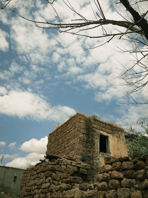 Free Rustic stone building under a scenic sky with scattered clouds, showcasing countryside charm. Stock Photo
