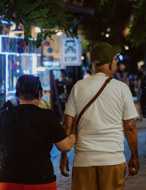 Free A senior couple enjoying a serene walk through a vibrant night market in Malay, Philippines. Stock Photo