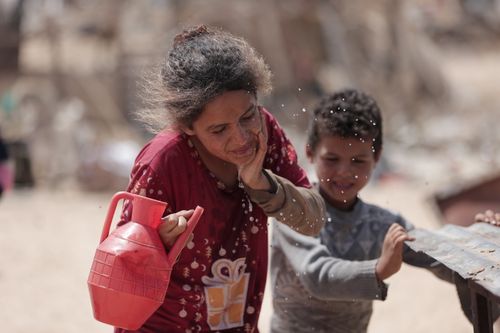 Free A candid moment capturing a boy and woman in Gaza, highlighting resilience and joy amidst challenges. Stock Photo