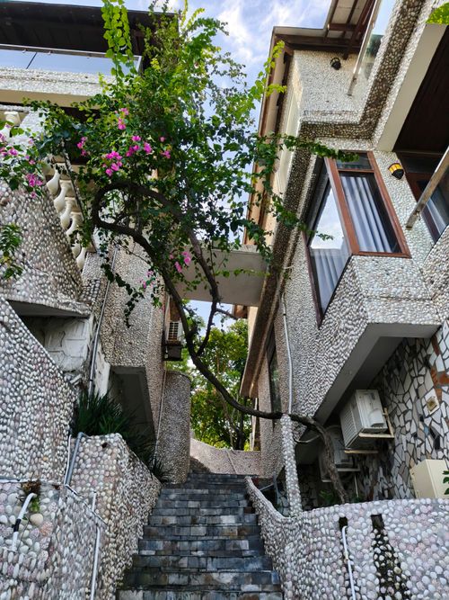 Free Charming pebble-adorned house and stairs with vibrant bougainvillea in Bình Thuận, Vietnam. Stock Photo