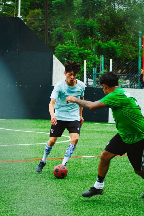 Free Intense soccer match on a sports court in Mexico City. Players exhibit skill and teamwork outdoors. Stock Photo
