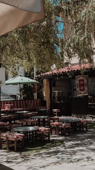 Explore the tranquility of a traditional outdoor cafe setting in Bosnia with rustic decor and shaded seating.