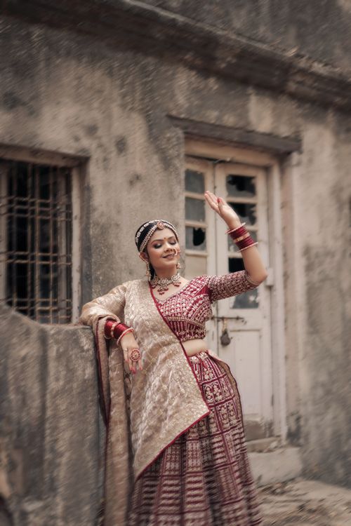 Free Beautiful woman in traditional Indian dress posing against a vintage building backdrop. Stock Photo