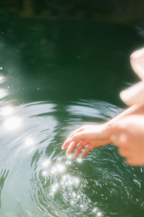 Free A gentle hand touching shimmering water in Lạng Sơn, Việt Nam. Stock Photo