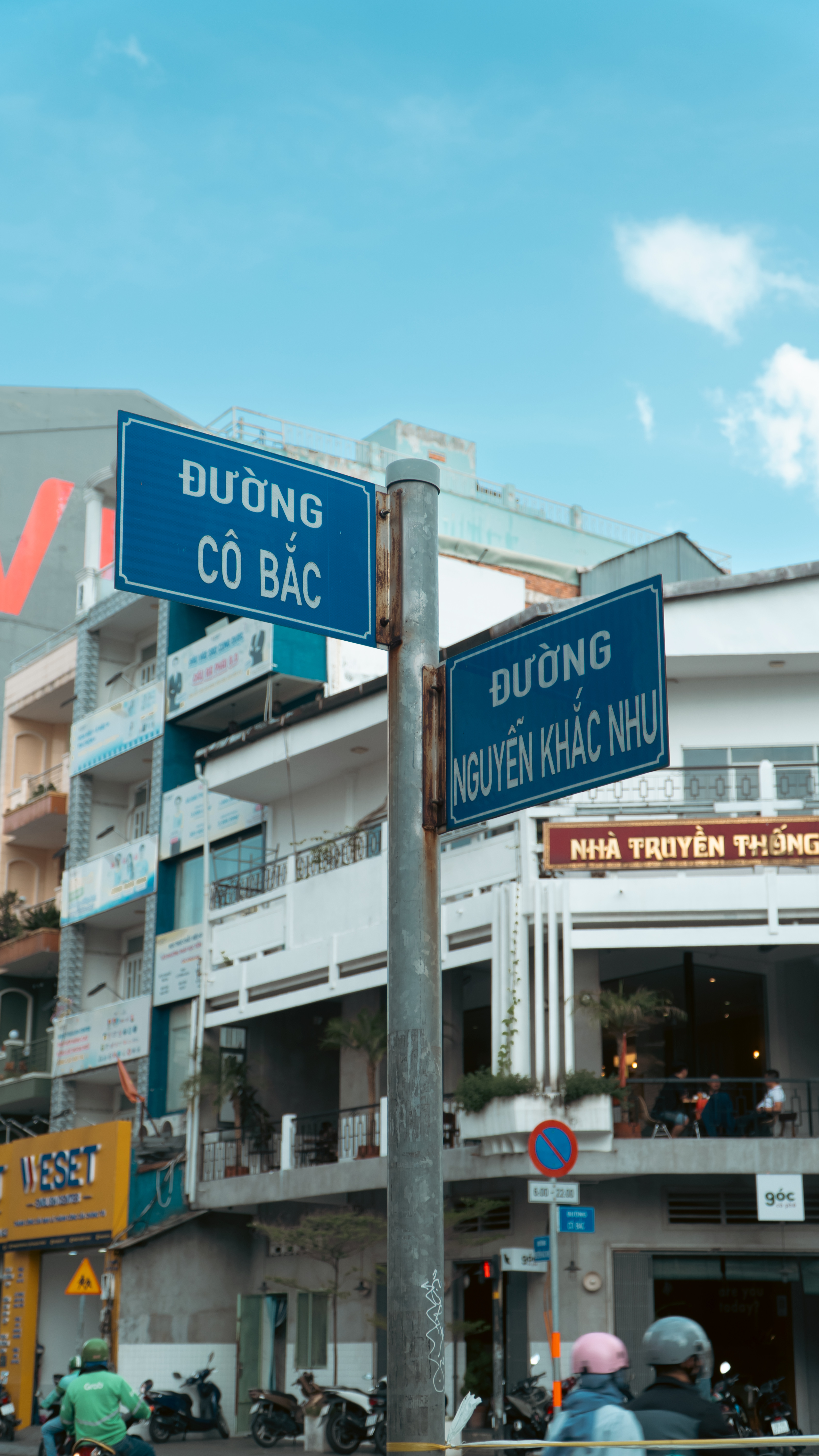 Busy street intersection in Vietnam showing local street signs with Vietnamese text.
