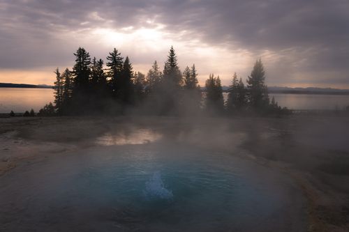 Free Sunset view of a steaming geyser in Yellowstone National Park, Wyoming. Stock Photo
