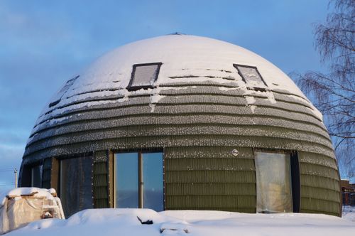 Free A distinctive dome-shaped house with snow under a blue winter sky, illustrating unique architecture. Stock Photo