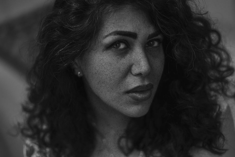 Black and white portrait of a woman with curls and freckles