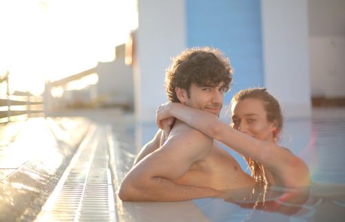 Free Young couple enjoying a sunny day in the swimming pool, showcasing love and togetherness. Stock Photo