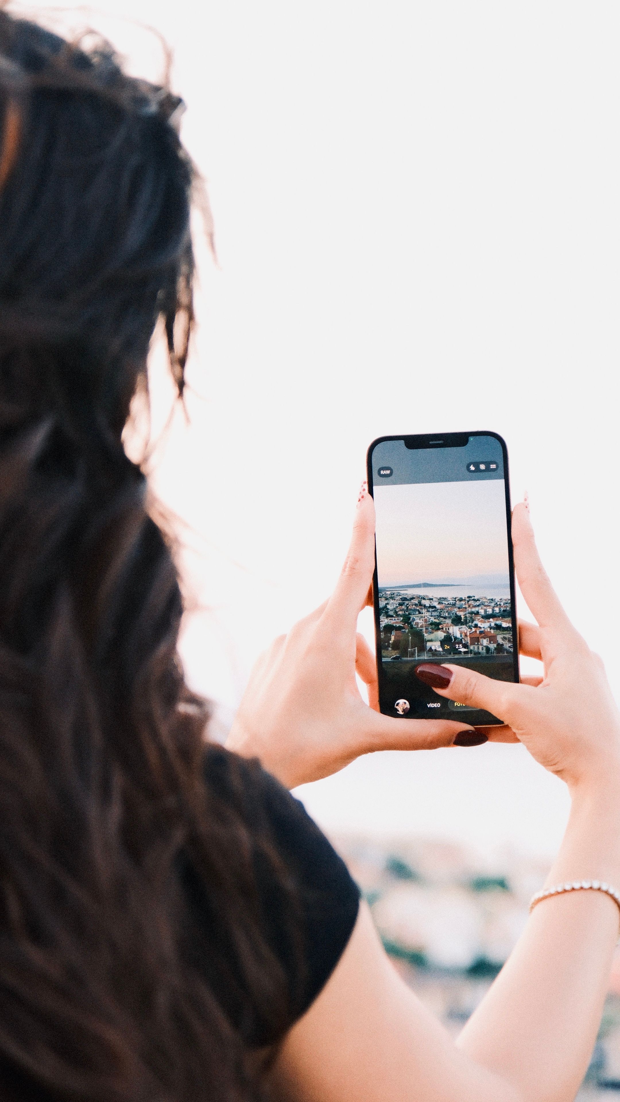 A person photographing a cityscape with a smartphone, highlighting urban exploration.
