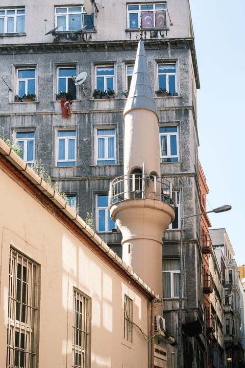 Free A narrow street in Istanbul featuring an unusual minaret against a residential building. Stock Photo