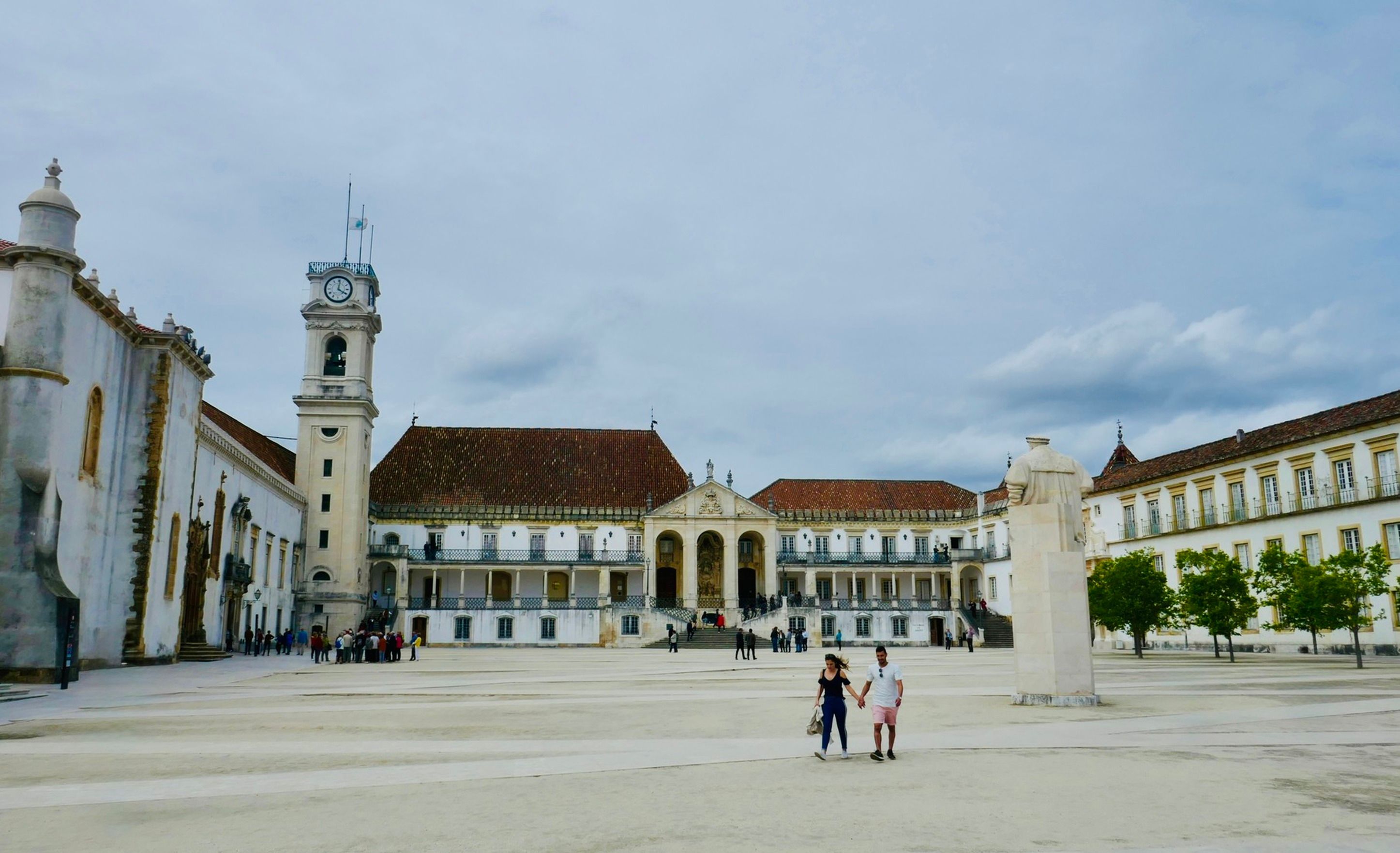 Pessoas a caminhar numa rua movimentada do centro de Coimbra, em Portugal, durante a hora de ponta