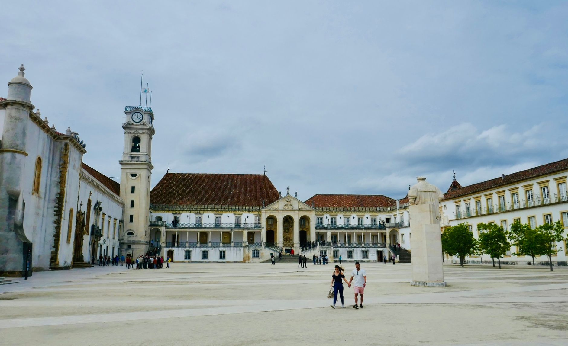 Pessoas a caminhar numa rua movimentada do centro de Coimbra, em Portugal, durante a hora de ponta