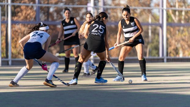 Female field hockey players in action during a competitive match outdoors., free online jigsaw puzzle on JigsawPuzzlesFreeOnline.org