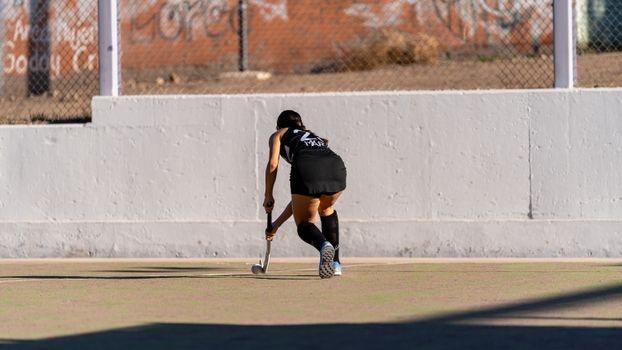 A female field hockey player in action, focusing on the game outdoors.