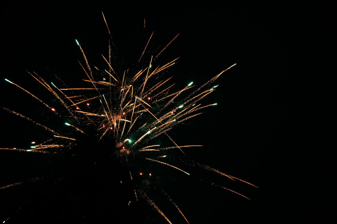Free Vibrant fireworks exploding against a dark night sky, creating dazzling light patterns. Stock Photo