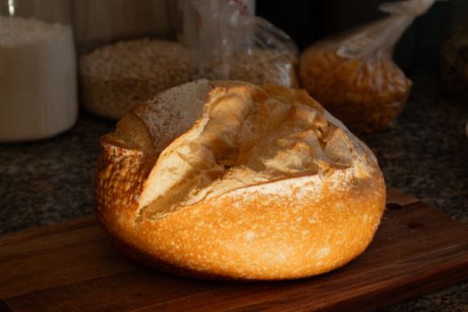 A warm loaf of crusty bread sits on a kitchen counter, creating a homely and inviting scene.
